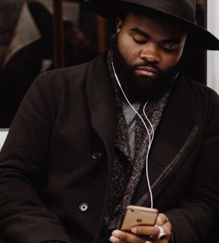 Un hombre mira su teléfono mientras escucha La Biblia en Un Año